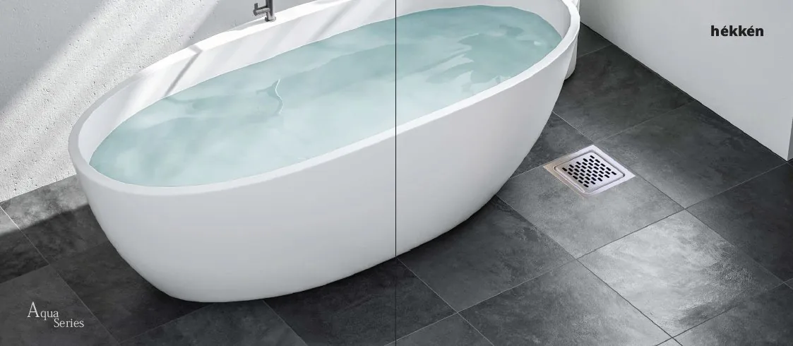 hékkén Aqua Series — freestanding bathtub with floor drain on slate tiles
